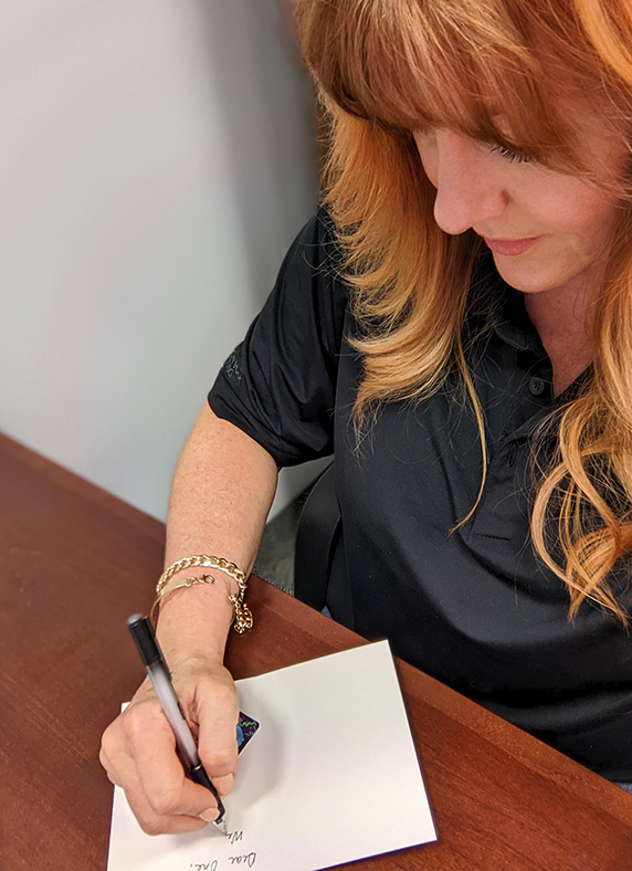 Woman volunteer writes a note of encouragement.